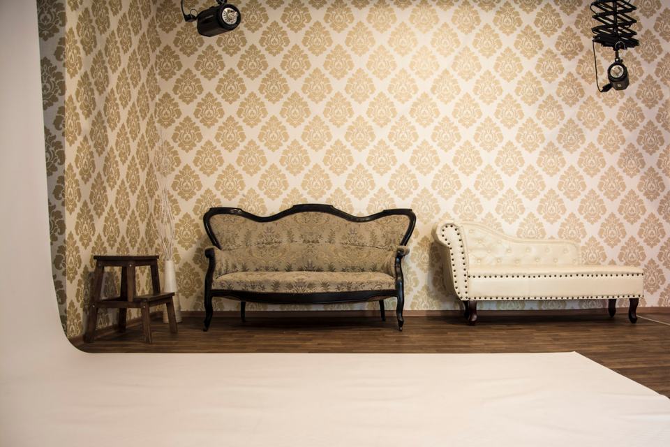 Tapetovaná stage s pohovkou a šezlongem ve fotoateliéru I. P. Pavlova, připravená na portrét a boudoir
